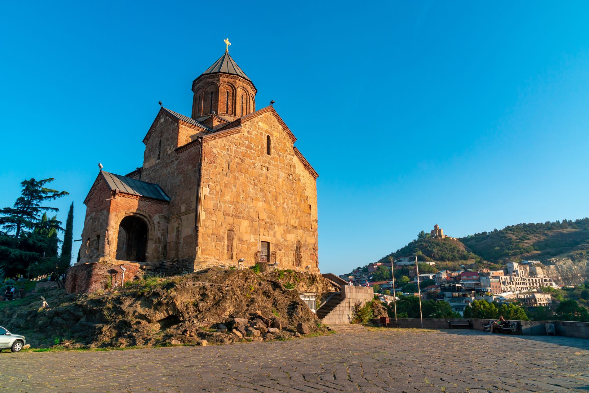 Side view of Metekhi Church with mountains in the background — a historic site central to Tbilisi’s origin