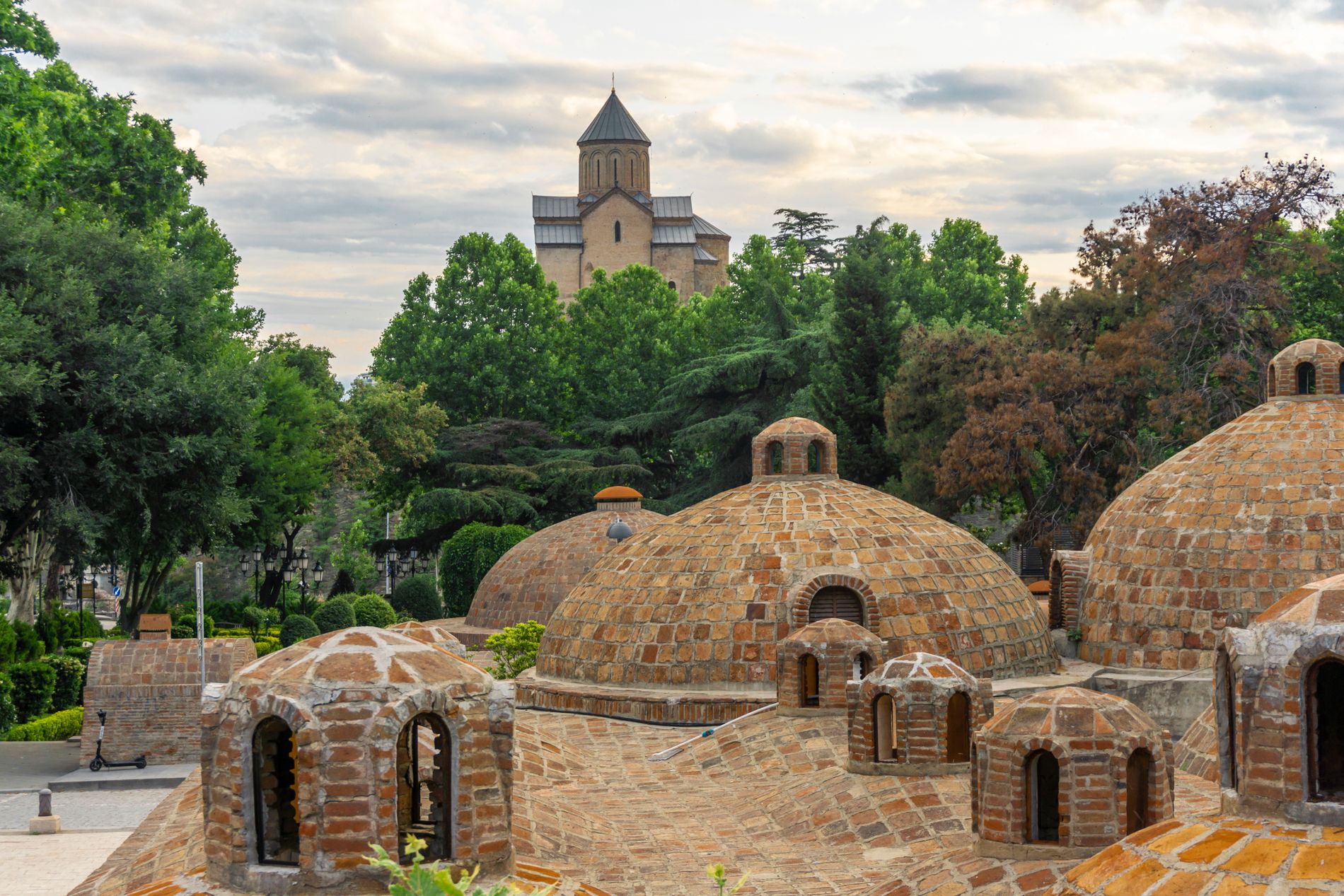 Sulfur Baths in Tbilisi with golden dome of Holy Trinity Cathedral in the distance — blend of wellness and cityscape