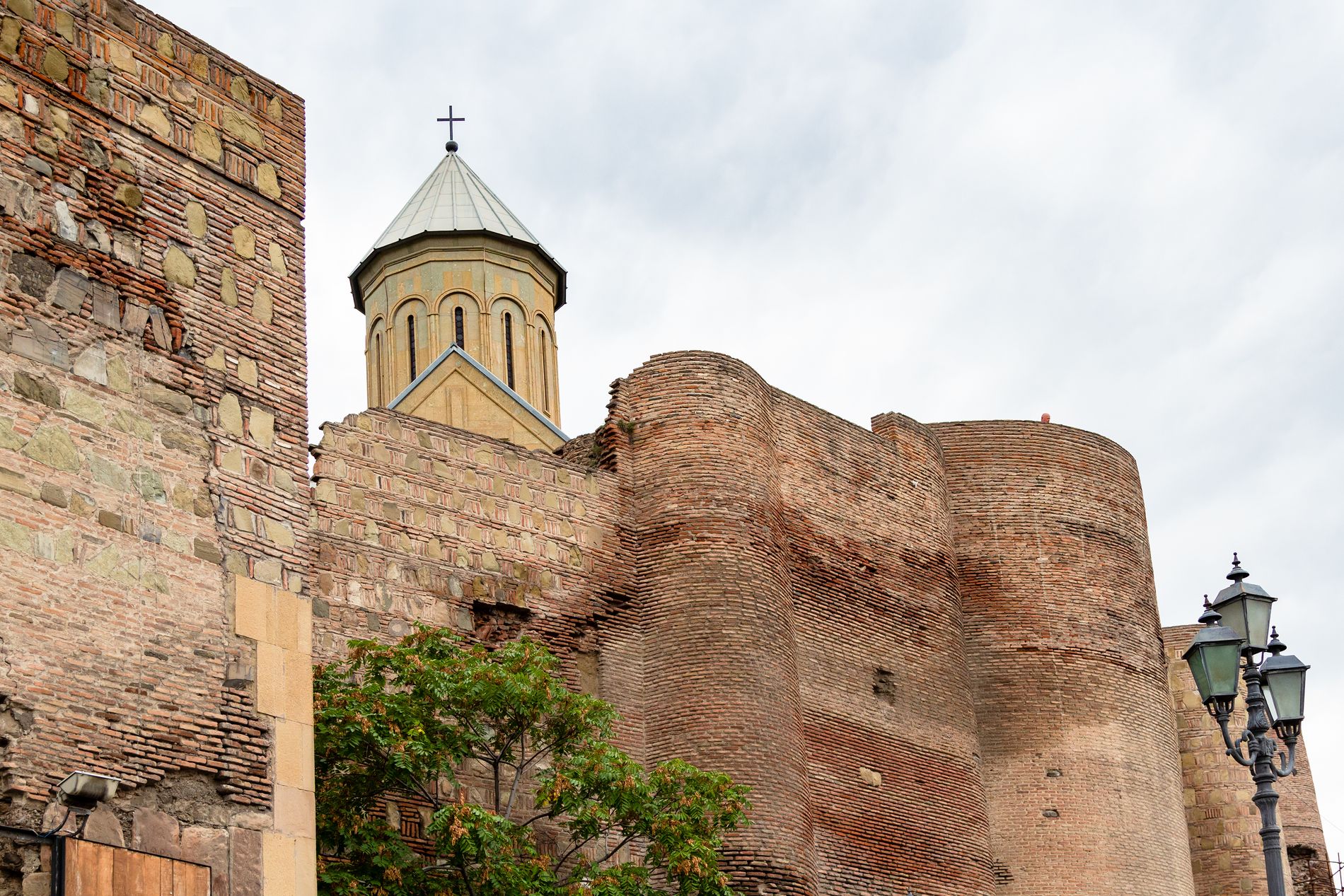 Ancient stone walls of Narikala Fortress — centuries-old fortifications overlooking Tbilisi from the hillside above the Old Town