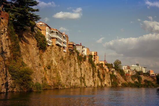 Steep cliffs, traditional balconies and houses above the Mtkvari River — classic riverfront view of Old Tbilisi’s unique architecture