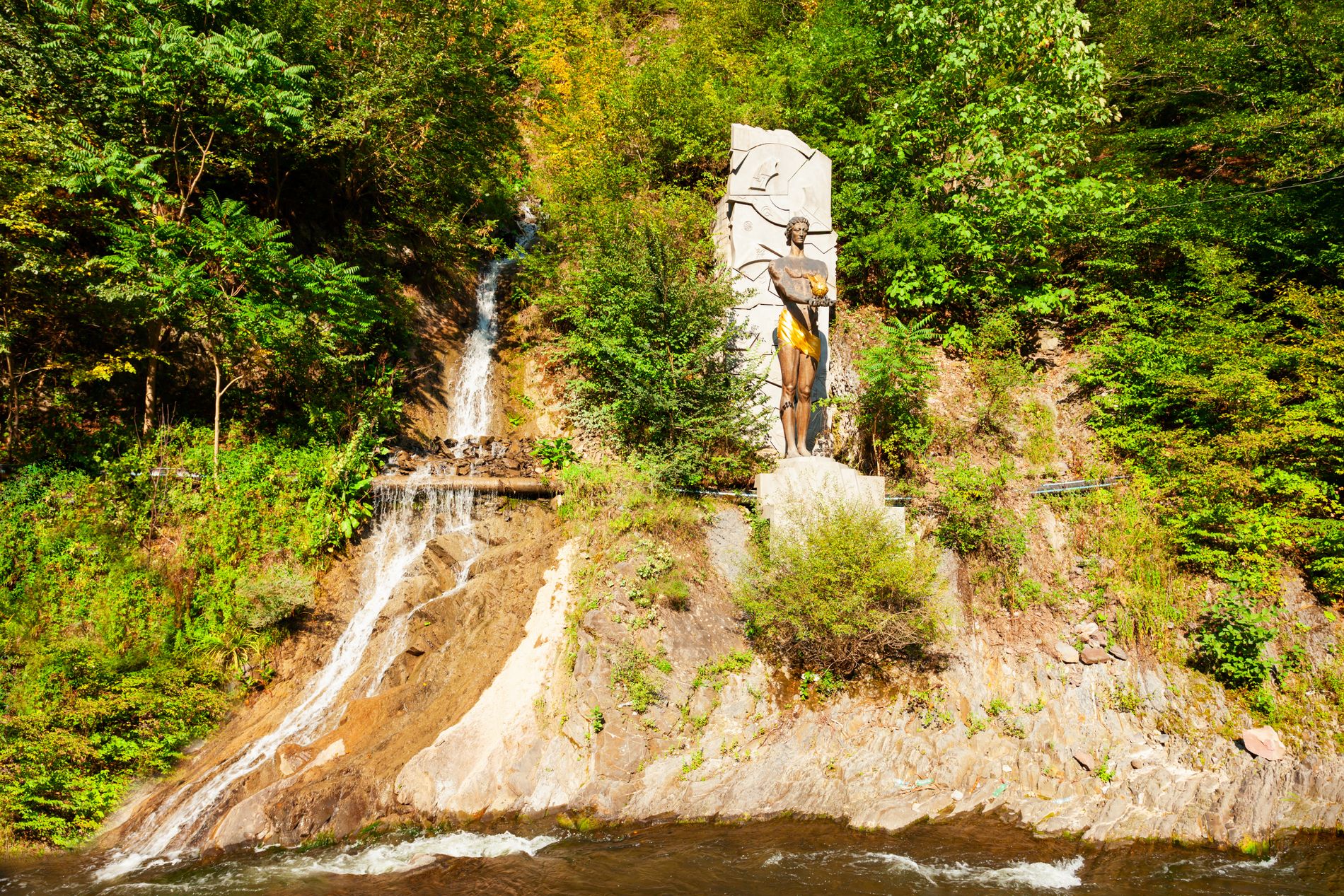 Prometheus statue standing near a small waterfall — mythological monument in Borjomi’s landscaped park