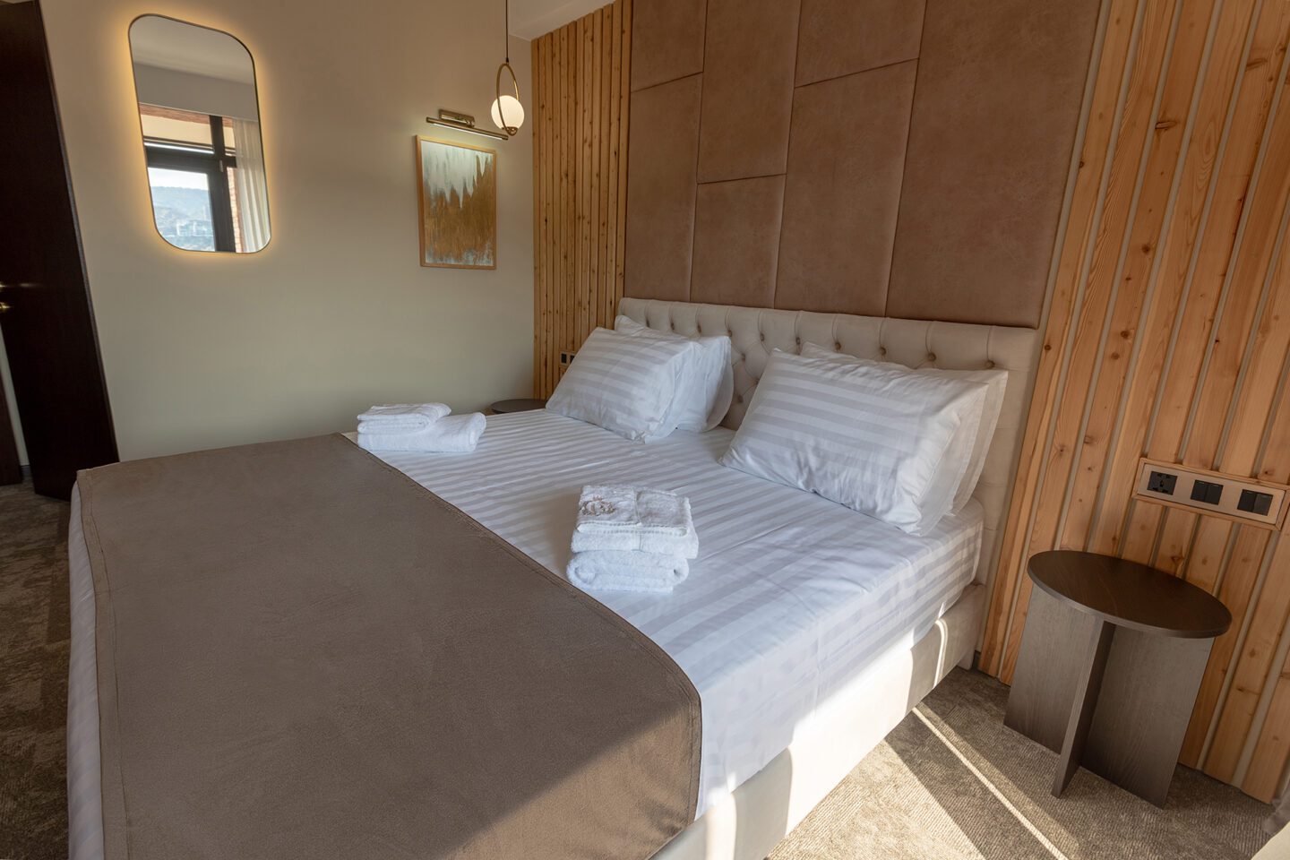 Cozy boutique hotel room with plush bedding and minimalist wall decor — Bellevue Deluxe Flex room in Tbilisi, Georgia