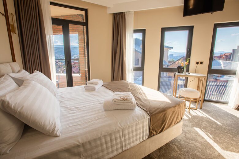 Premier room in Tbilisi with extra-large bed, flat-screen TV and panoramic windows — sunlight and skyline view from Bellevue Boutique Hotel