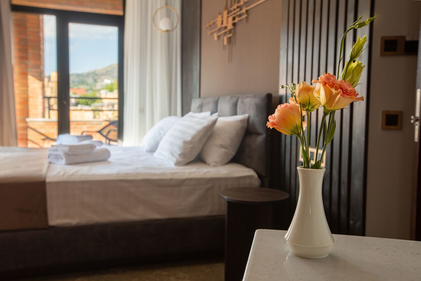 Fresh flowers placed by the bed — flower delivery available to your room at Bellevue Boutique Hotel in central Tbilisi