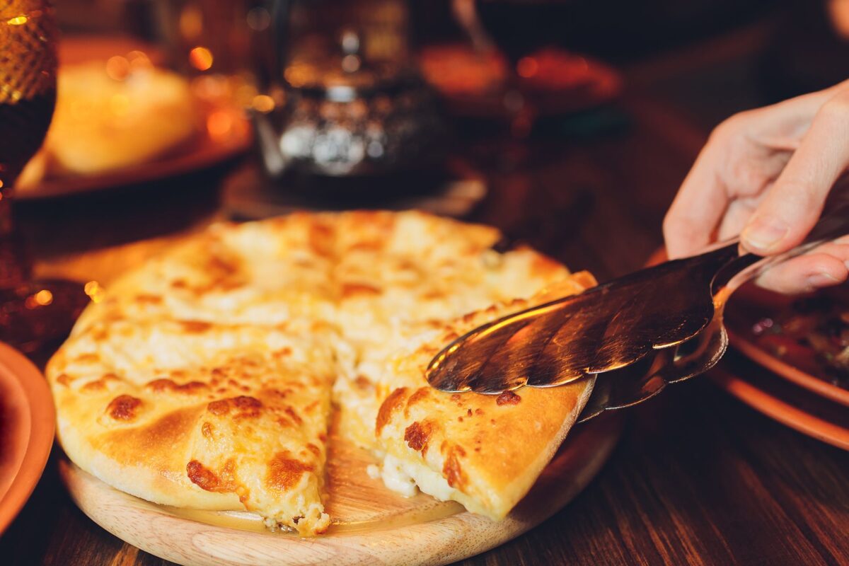 Megruli khachapuri — traditional Georgian flatbread with cheese inside and on top, served golden and warm