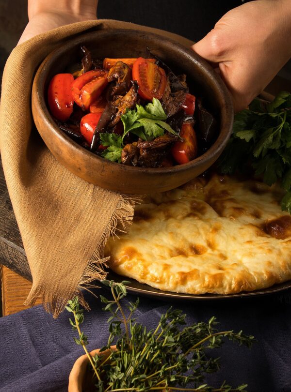 Classic Georgian salad with roasted eggplant and herbs, served alongside khachapuri — fresh and flavorful combination